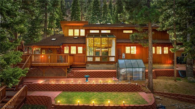 rear view of property featuring a wooden deck