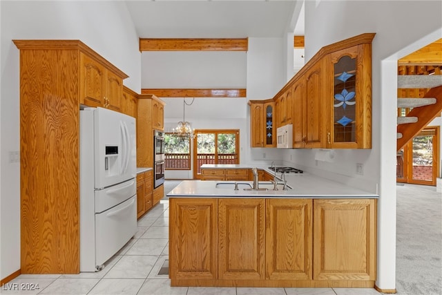 kitchen featuring appliances with stainless steel finishes, plenty of natural light, kitchen peninsula, and a chandelier