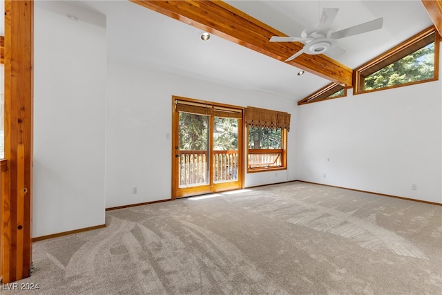 unfurnished room with ceiling fan, a wealth of natural light, light carpet, and vaulted ceiling with beams