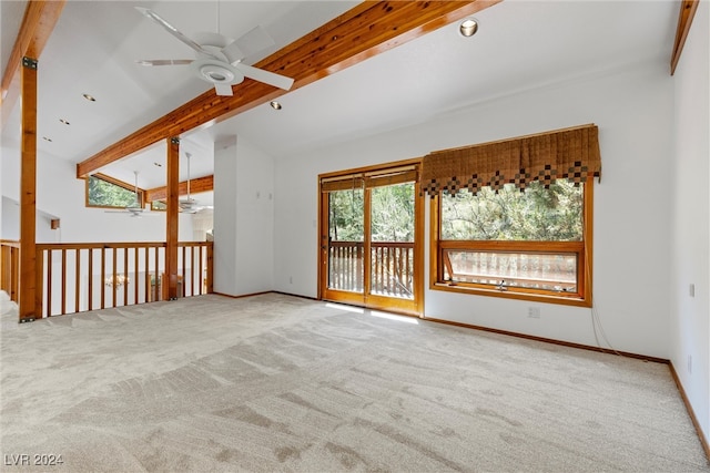 unfurnished room featuring a wealth of natural light, ceiling fan, light carpet, and vaulted ceiling with beams