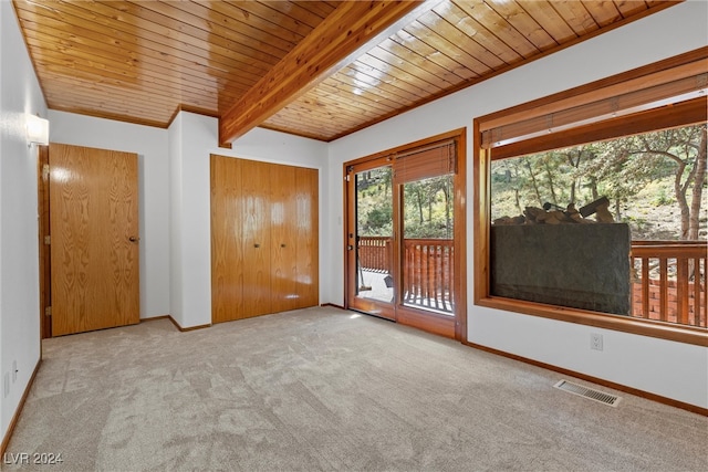 unfurnished room with light carpet, beam ceiling, and wooden ceiling