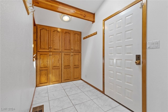 entrance foyer featuring vaulted ceiling with beams