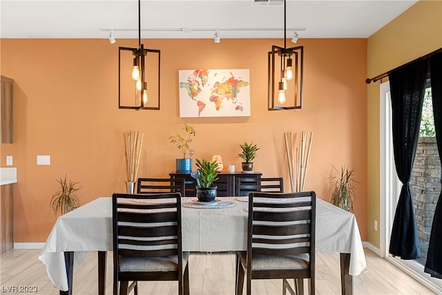 dining area with track lighting and light wood-type flooring