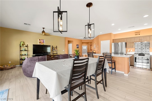 dining room with light hardwood / wood-style floors and an inviting chandelier