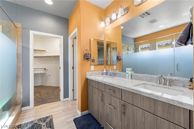 bathroom with tile flooring, dual sinks, walk in shower, and oversized vanity