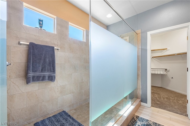 bathroom featuring tile flooring and tiled shower