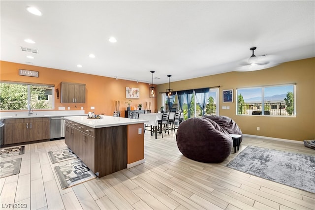 kitchen featuring ceiling fan, a kitchen island, a wealth of natural light, and pendant lighting