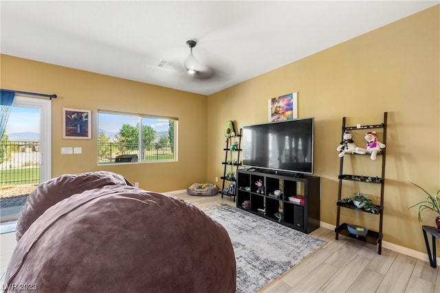 living room featuring ceiling fan and light wood-type flooring