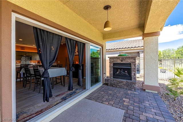 view of patio / terrace featuring an outdoor bar and an outdoor stone fireplace