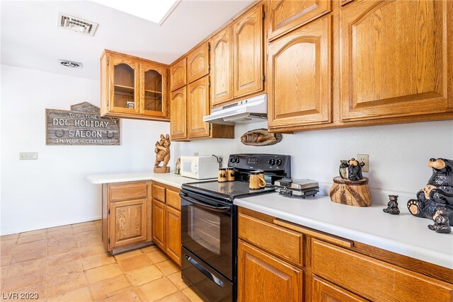 kitchen with black / electric stove and light tile flooring