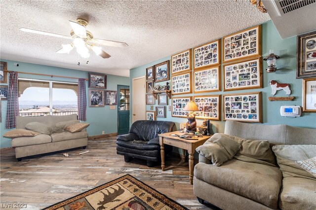 living room with dark hardwood / wood-style flooring, a textured ceiling, and ceiling fan