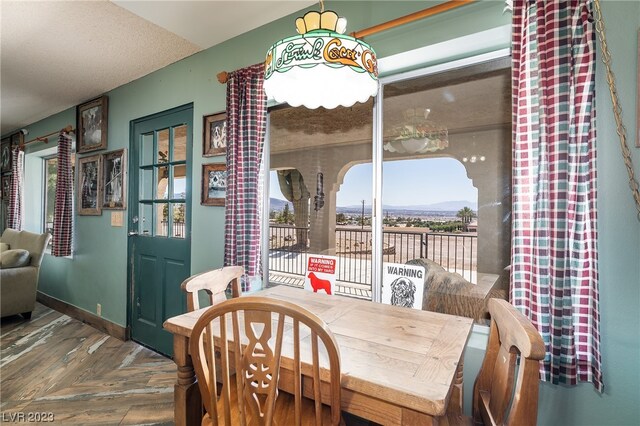 dining space featuring dark parquet floors and a healthy amount of sunlight