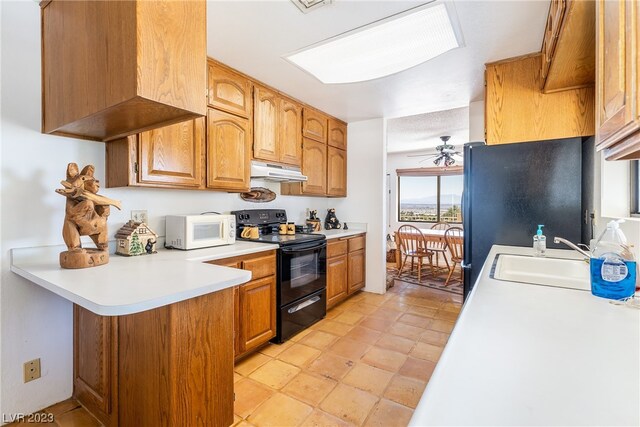 kitchen with light tile floors, ceiling fan, black appliances, and sink