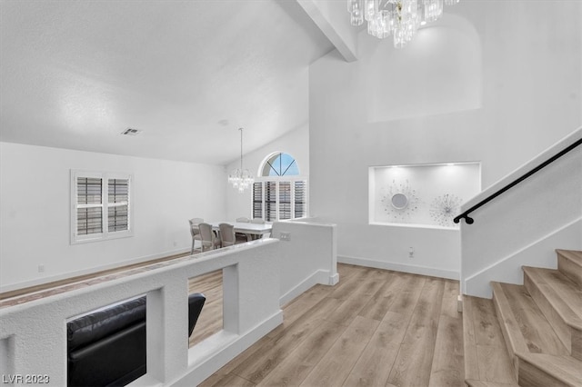 interior space with light hardwood / wood-style flooring, high vaulted ceiling, and a chandelier