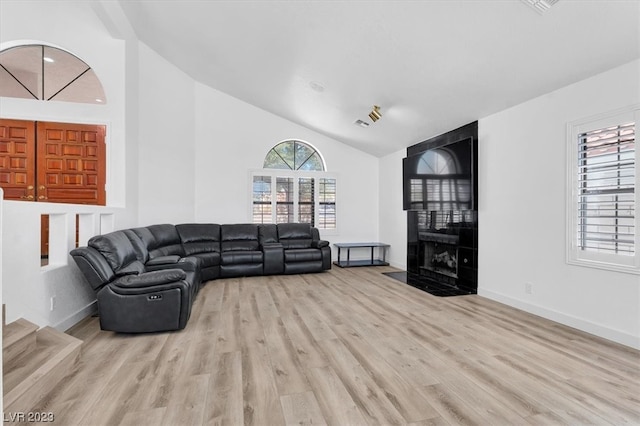 living room featuring high vaulted ceiling and light wood-type flooring