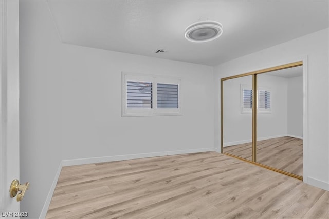 unfurnished bedroom featuring a closet and light hardwood / wood-style flooring