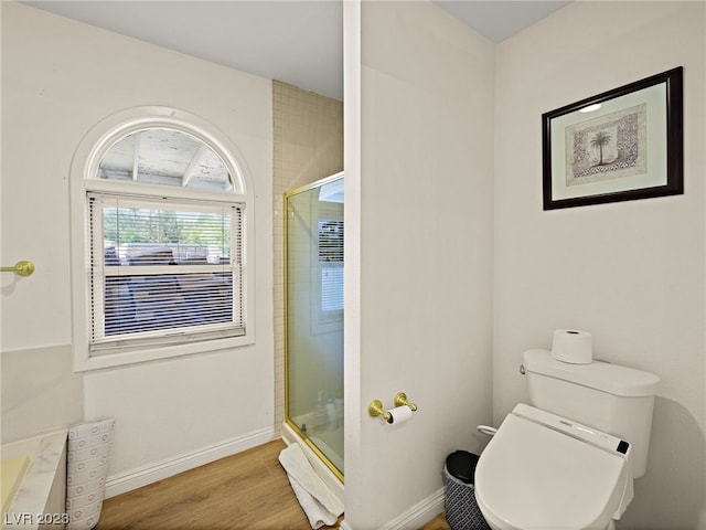 bathroom featuring hardwood / wood-style flooring, an enclosed shower, and toilet