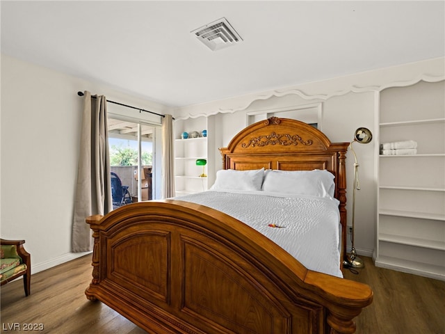 bedroom featuring access to exterior and dark wood-type flooring