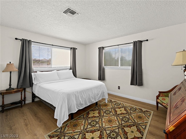 bedroom featuring a textured ceiling and wood-type flooring