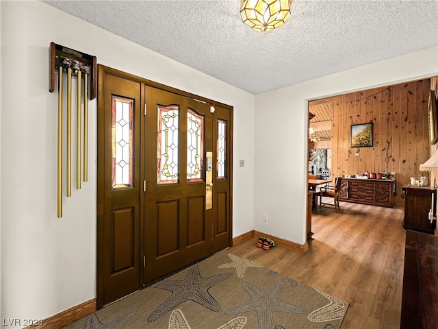 foyer entrance featuring a textured ceiling and dark hardwood / wood-style floors