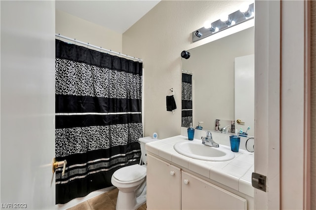 bathroom featuring toilet, tile flooring, and vanity