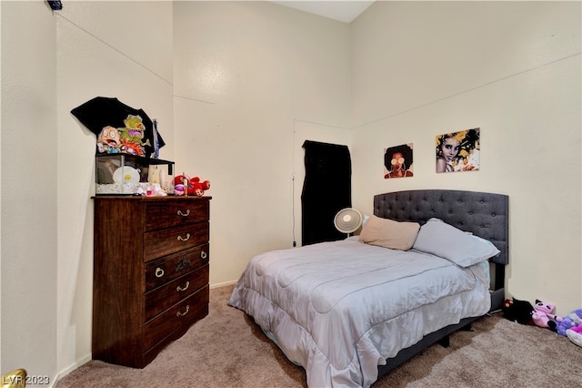 carpeted bedroom featuring a high ceiling