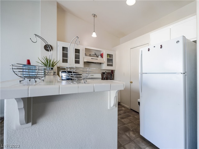 kitchen with white fridge, white cabinetry, premium range hood, and dark tile floors