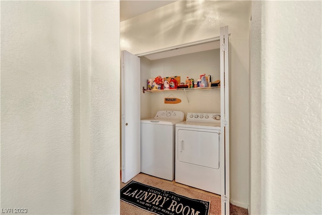 clothes washing area featuring separate washer and dryer and light colored carpet