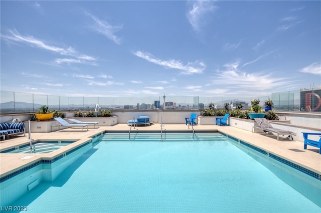 view of swimming pool featuring a hot tub and a patio area