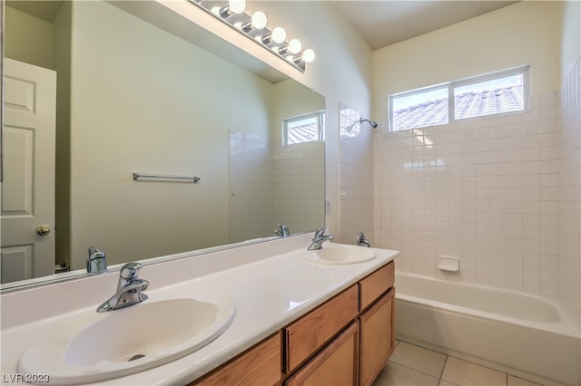 bathroom featuring dual sinks, oversized vanity, tile flooring, and tub / shower combination