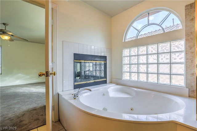 bathroom with plenty of natural light, tile floors, a washtub, and ceiling fan