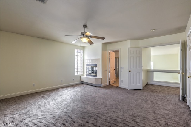 unfurnished bedroom with ceiling fan and dark carpet