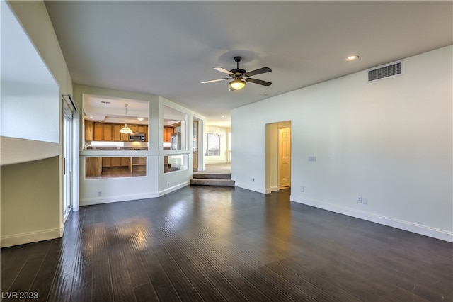 unfurnished living room with ceiling fan and dark hardwood / wood-style floors