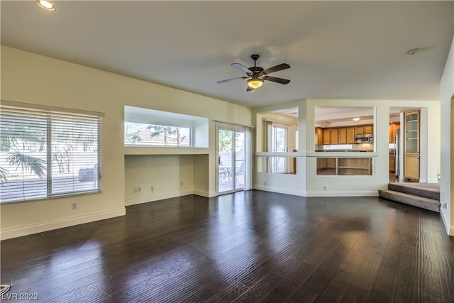 unfurnished living room featuring ceiling fan and dark hardwood / wood-style floors