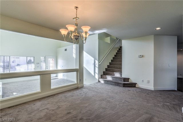 unfurnished room with a chandelier and dark colored carpet