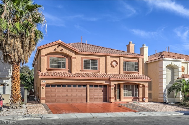 mediterranean / spanish-style home with central air condition unit and a garage