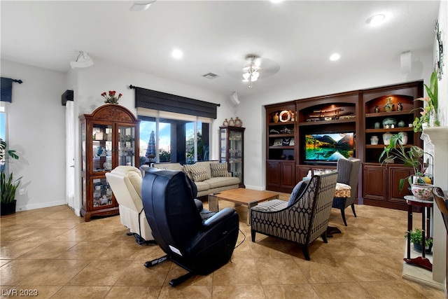 tiled living room with ceiling fan and built in features