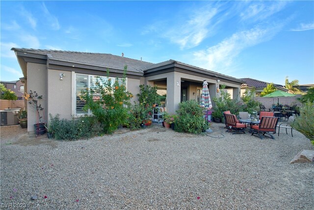 back of property with central air condition unit and a patio area