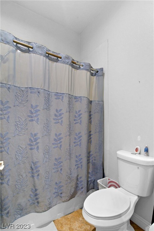 bathroom featuring toilet and tile floors