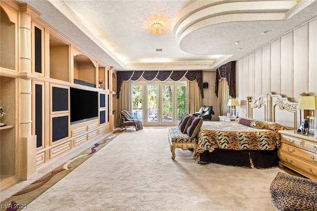 bedroom with a raised ceiling, access to exterior, carpet, and a textured ceiling