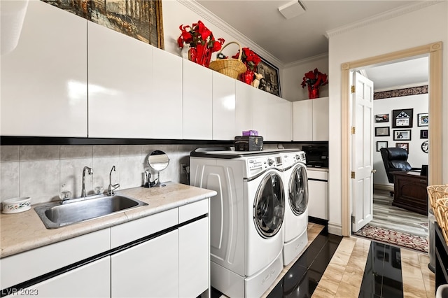 washroom with cabinets, ornamental molding, washer and clothes dryer, sink, and hardwood / wood-style floors