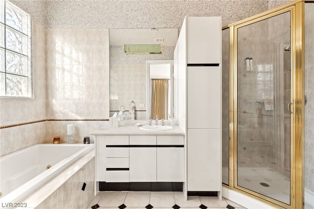 bathroom featuring tile patterned floors, vanity, and shower with separate bathtub