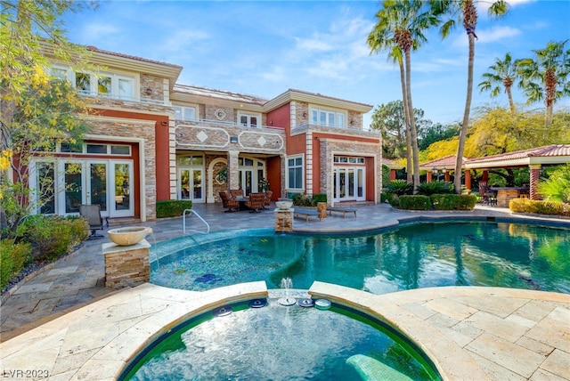 view of pool with a patio area, an in ground hot tub, and french doors