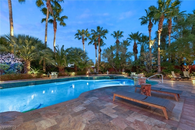 pool at dusk with a patio