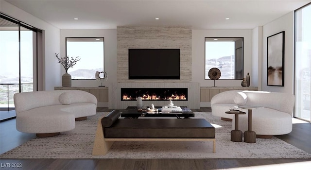 living room featuring hardwood / wood-style flooring, plenty of natural light, and a large fireplace