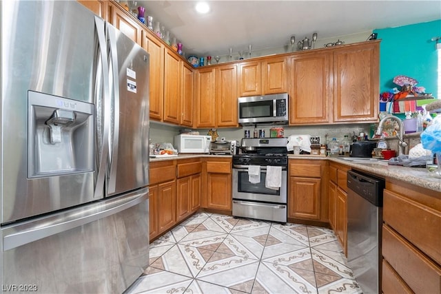 kitchen with light tile patterned floors, sink, and appliances with stainless steel finishes