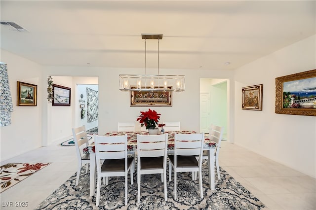 dining area with light tile patterned flooring, a notable chandelier, visible vents, and baseboards