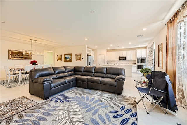 living room with light tile patterned floors, visible vents, and recessed lighting