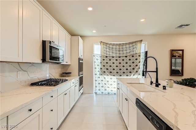 kitchen featuring light tile patterned floors, visible vents, appliances with stainless steel finishes, white cabinetry, and a sink