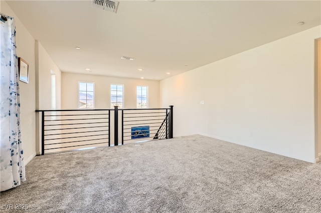 unfurnished room with carpet and visible vents